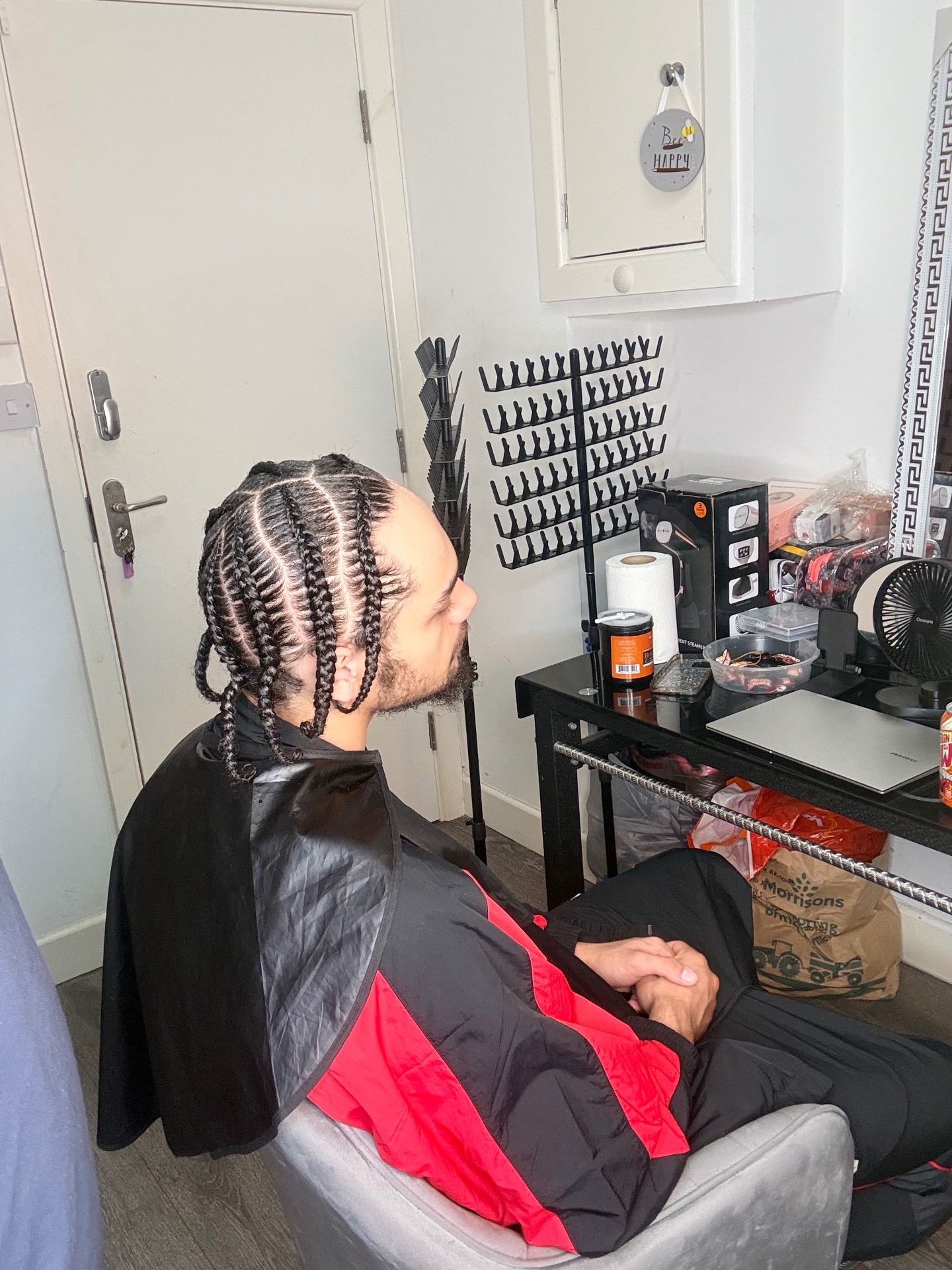 Men's cornrows with neat parting, styled at the studio