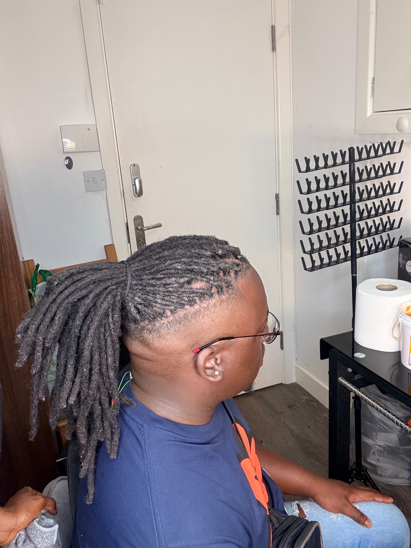 Freshly retwisted locs tied into a ponytail at the Leeds studio