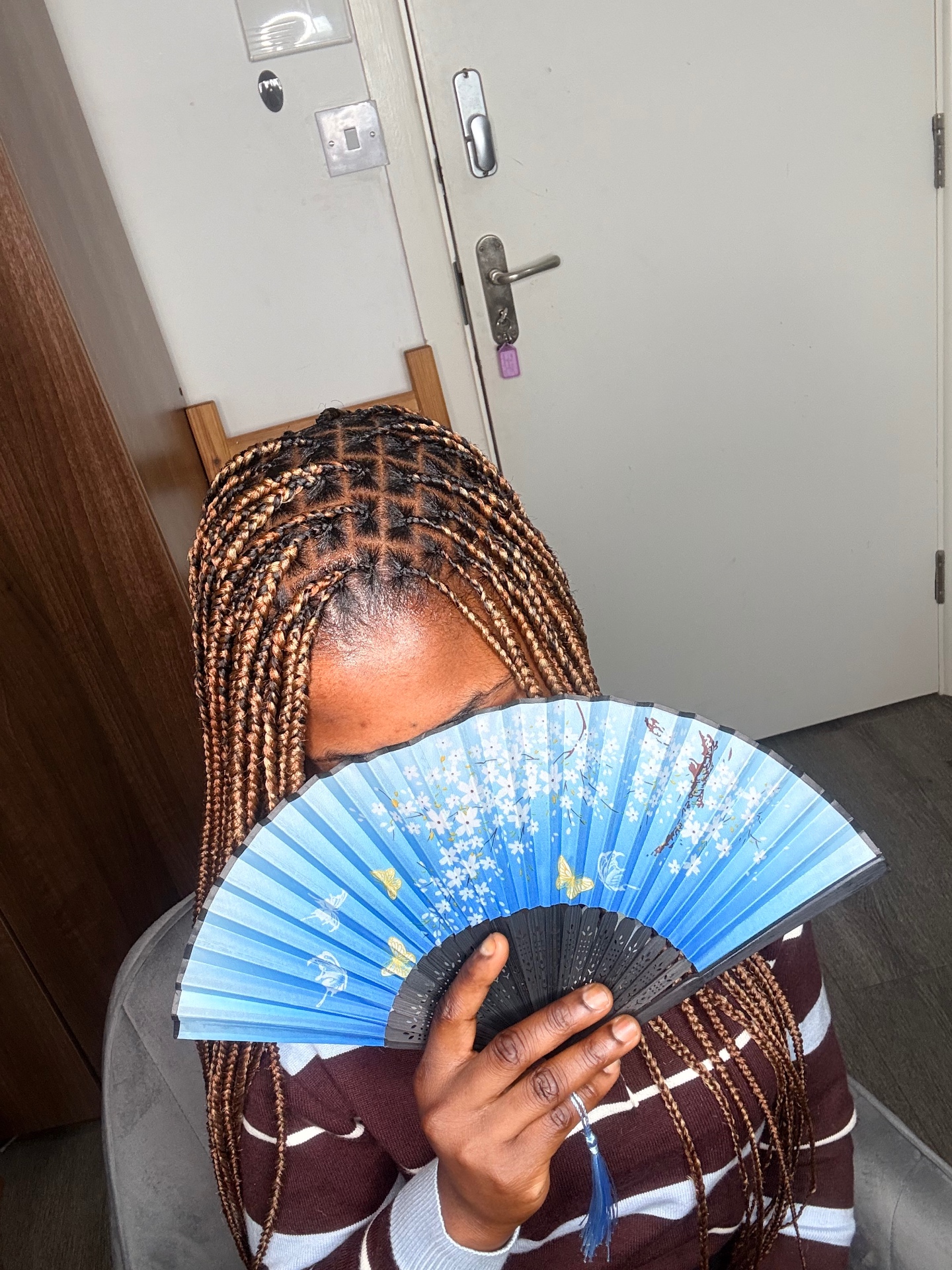 Knotless braids with copper tones and a decorative fan styled at the Leeds studio